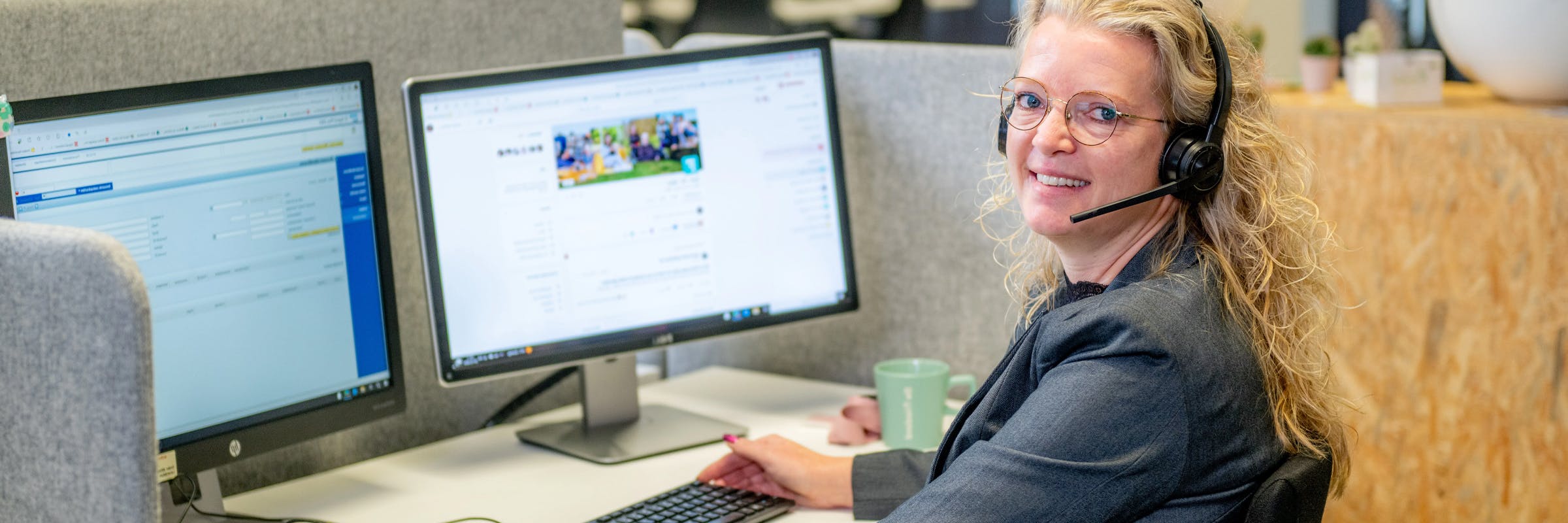 Medewerker klantcontact bij De Friesland achter bureau en computer