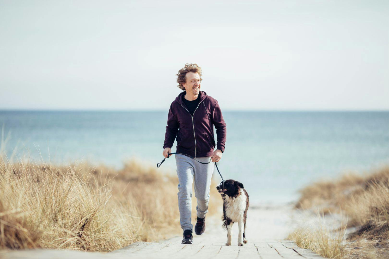 Man met hond in duinen
