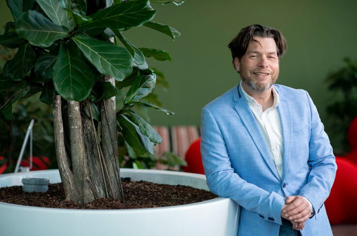 Rudin Eijgelaar poseert bij het kantoor van De Friesland