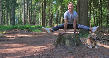 Epke Zonderland in spreidstand op een boomstam