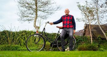 Wiebe Tolsma, deelnemer Fietselfstedentocht 2024, staat buiten voor een zwarte weduwe fiets