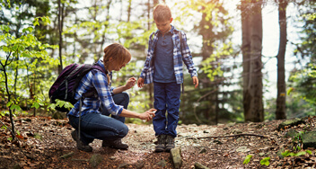 Vrouw met zoontje in bos